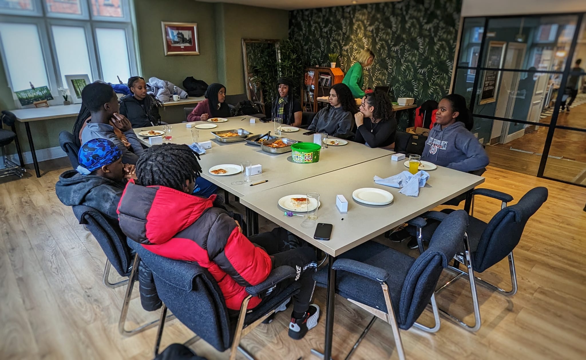 Belonging cohort sat around a table at Saints